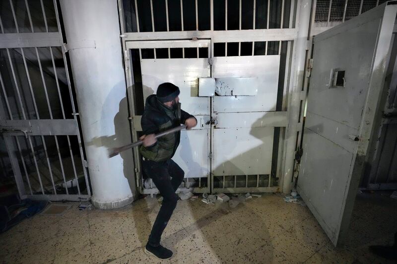 A man breaks a lock of a cell in the prison (Hussein Malla/AP)