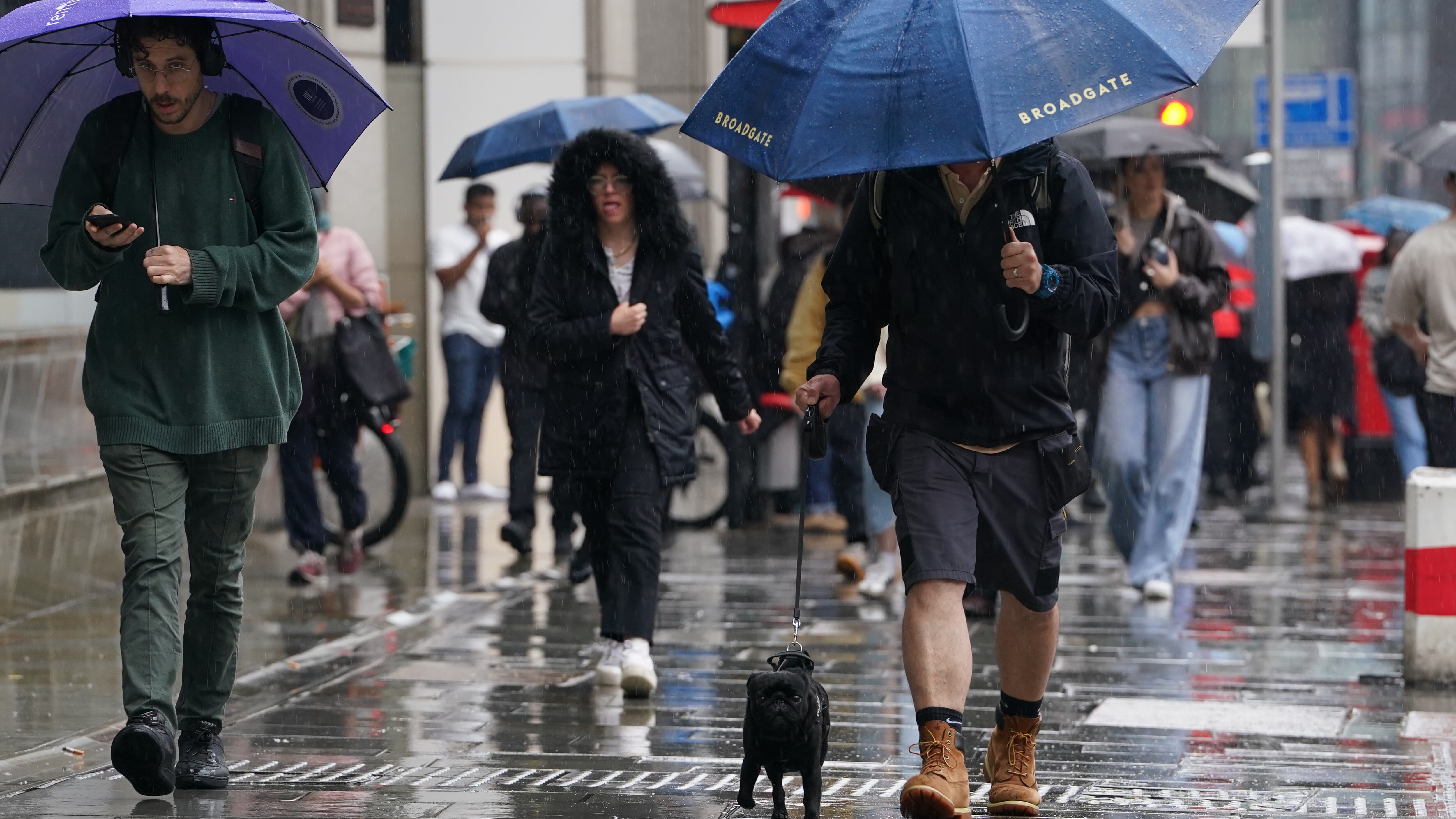 People walk in the rain near Liverpool Street in London on Tuesday