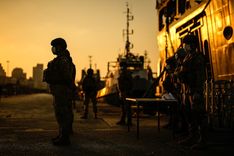 Turkish security officials stand guard next to Turkish military ships preparing to evacuate citizens from Lebanon to Turkey in Beirut port (Emrah Gurel/AP)