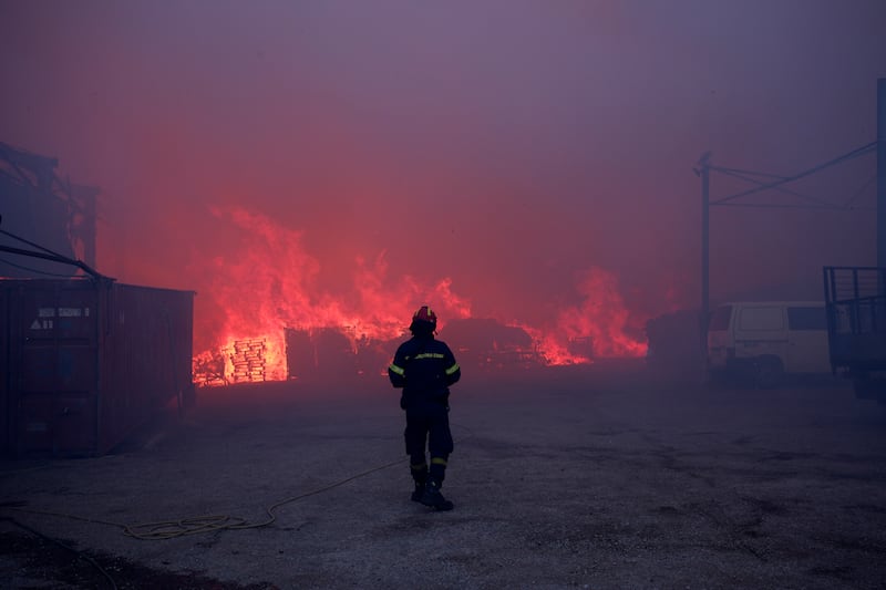 Dozens of homes and businesses were reported to have burned (Aggelos Barai/AP)