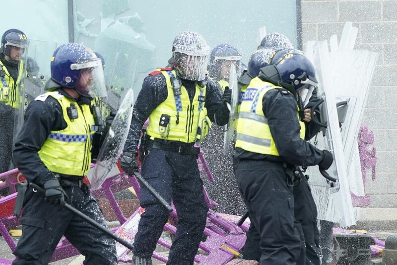 Fire extinguishers are used on police officers as trouble flares during an anti-immigration protest outside the Holiday Inn Express in Rotherham, South Yorkshire