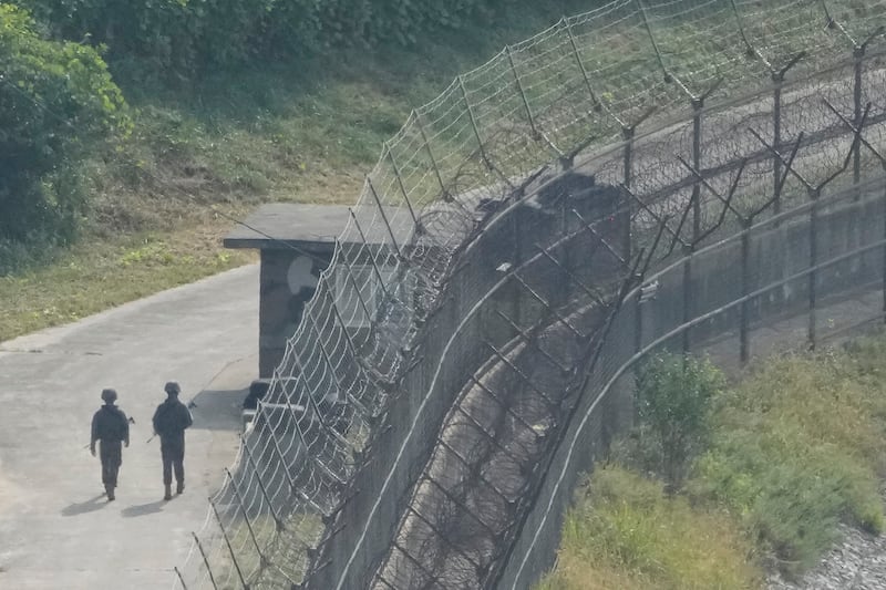 South Korean army soldiers patrol along the barbed-wire fence in Paju, South Korea, near the border with North Korea (Ahn Young-joon/AP)