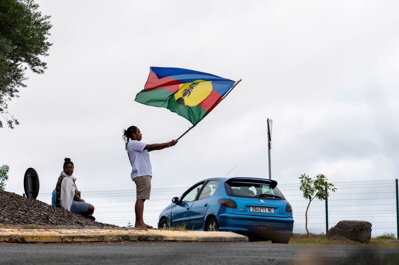 A woman waves a Kanak and Socialist National Liberation Front flag in Noumea, New Caledonia (Nicolas Job/AP)