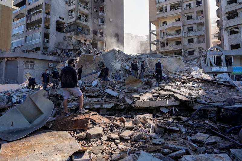 Residents check the site of an Israeli airstrike in Tayouneh, Beirut (Hassan Ammar/AP)