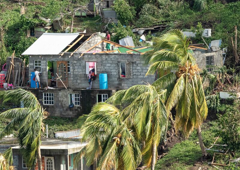 Family members begin to repair their home damaged in the passing of Hurricane Beryl, in Ottley Hall, St Vincent and the Grenadines (Lucanus Ollivierre/AP)