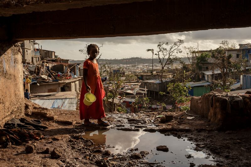 A young girl stands amid the devastation after Cyclone Chido (Adrienne Surprenant/AP)