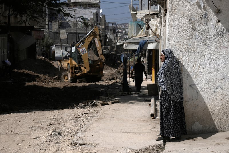 A Palestinian woman watches an operation by the Israeli military in Tulkarem refugee camp in the West Bank (Majdi Mohammed/AP)