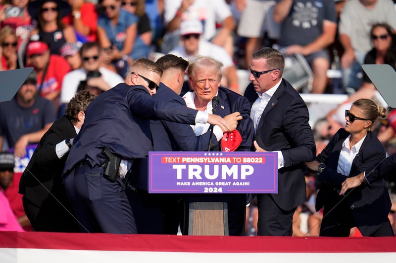 Donald Trump was helped off by bodyguards (Gene J. Puskar/AP)