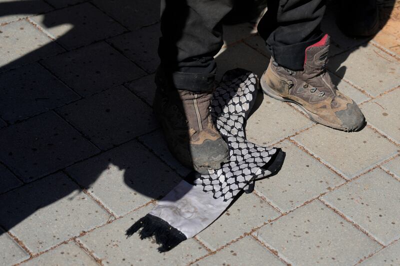 Right-wing Israelis, one stomping on a Palestinian scarf, protest outside of the hearing (Ohad Zwigenberg/AP)