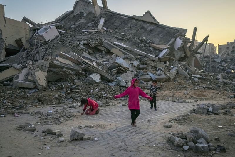 Palestinian children play next to a building destroyed by Israeli army strikes (AP Photo/Abdel Kareem Hana)