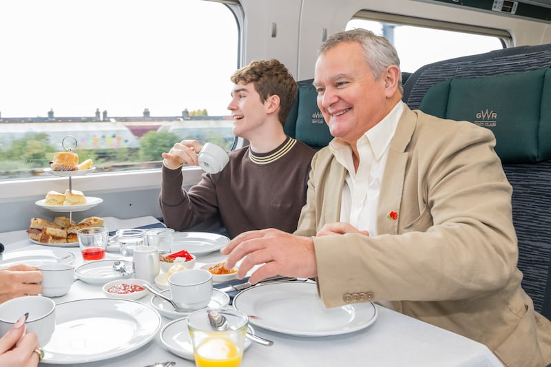 Hugh Bonneville and Samuel Joslin enjoying tea on board the Paddington Peru Express