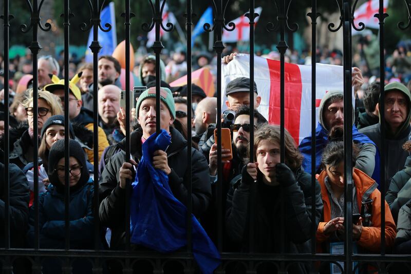 People listen to outgoing Georgian President Salome Zourabichvili speaking outside of the Orbeliani Palace, the official residence of the President of Georgia (AP/Zurab Tsertsvadze)