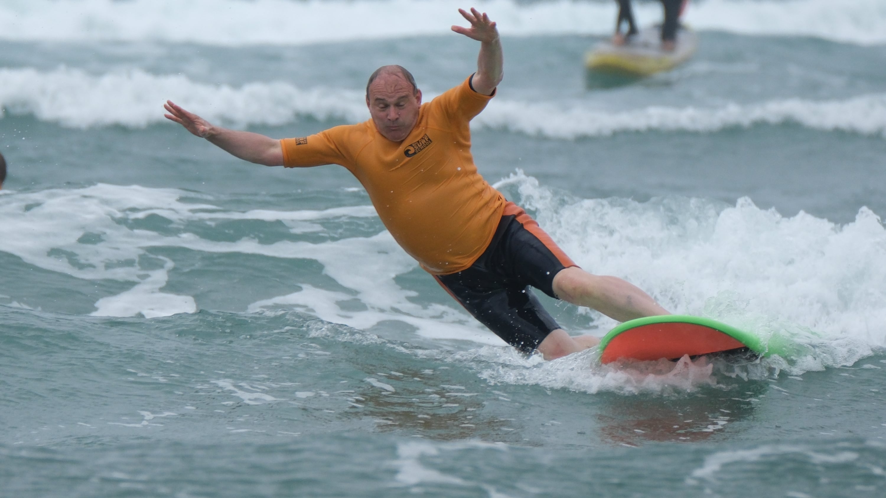 Liberal Democrat leader Sir Ed Davey falls from a surfboard during a visit to Big Blue Surf School in Bude, Cornwall