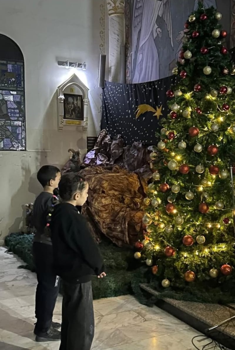 Children in Holy Family Parish in Gaza City parish admire the Christmas tree after this year's Advent service PICTURE: ACN