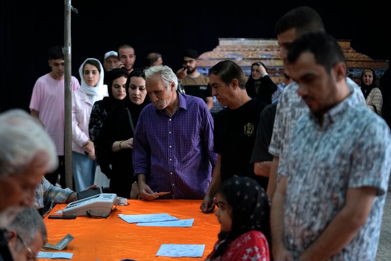 People line up to get their ballots to vote in the presidential election at a polling station in Tehran (Vahid Salemi/AP)
