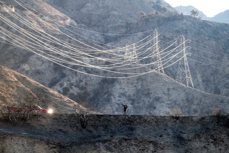 A firefighter takes weather readings (Noah Berger/AP)