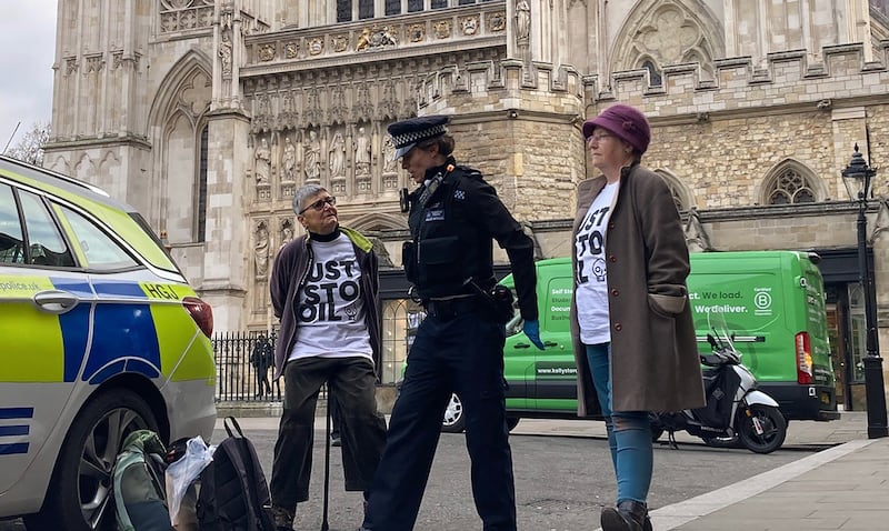 Just Stop Oil protesters Di Bligh, 77, and Alyson Lee, 66, with a police officer outside Westminster Abbey