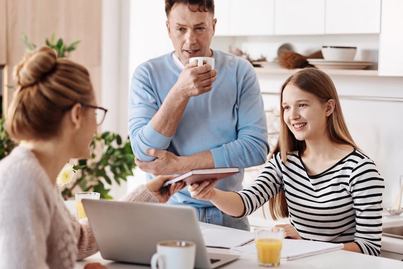 HY0GMT Positive parents checking homework of their daughter