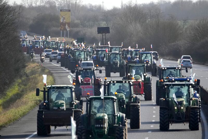 Farmers drive their tractors on a motorway near Saint-Arnoult, south of Paris on their way to a blockade (Christophe Ena/AP)