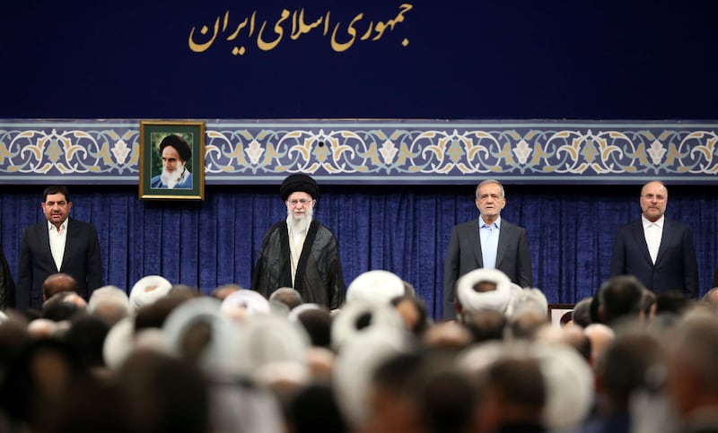 (L to R) Acting Iranian president Mohammad Mokhber, Supreme Leader Ayatollah Ali Khamenei, newly elected President Masoud Pezeshkian, and Parliament Speaker Mohammad Bagher Qalibaf listen to the national anthem at the start of the endorsement ceremony (Office of the Iranian Supreme Leader/AP)