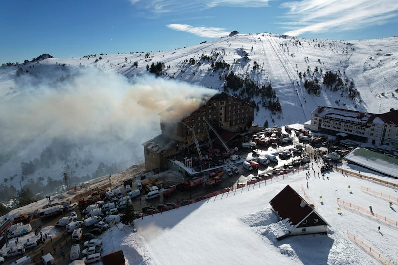 Firefighters work to extinguish a fire in a hotel at the ski resort of Kartalkaya, located in Bolu province, Turkey (Enes Ozkan/IHA via AP)