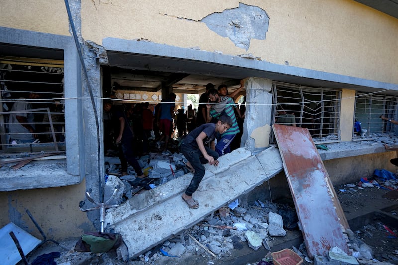 Palestinians search for the bodies of relatives killed in an Israeli bombardment in Deir al-Balah (Abdel Kareem Hana/AP)