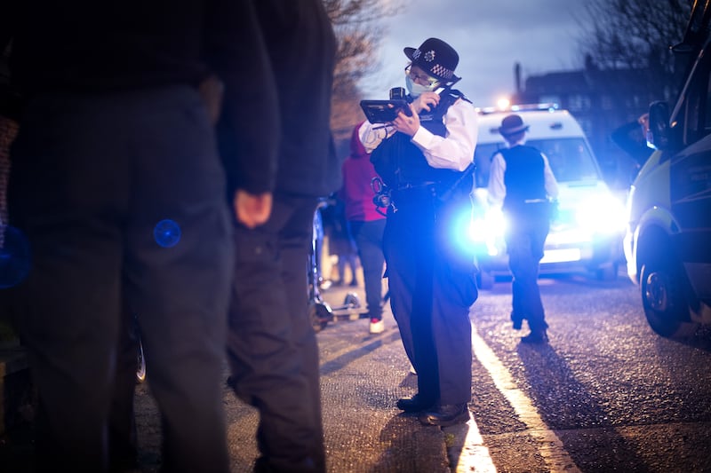 A police officer uses her radio during a stop and search