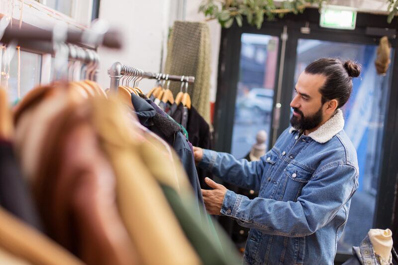 man choosing clothes at vintage clothing store