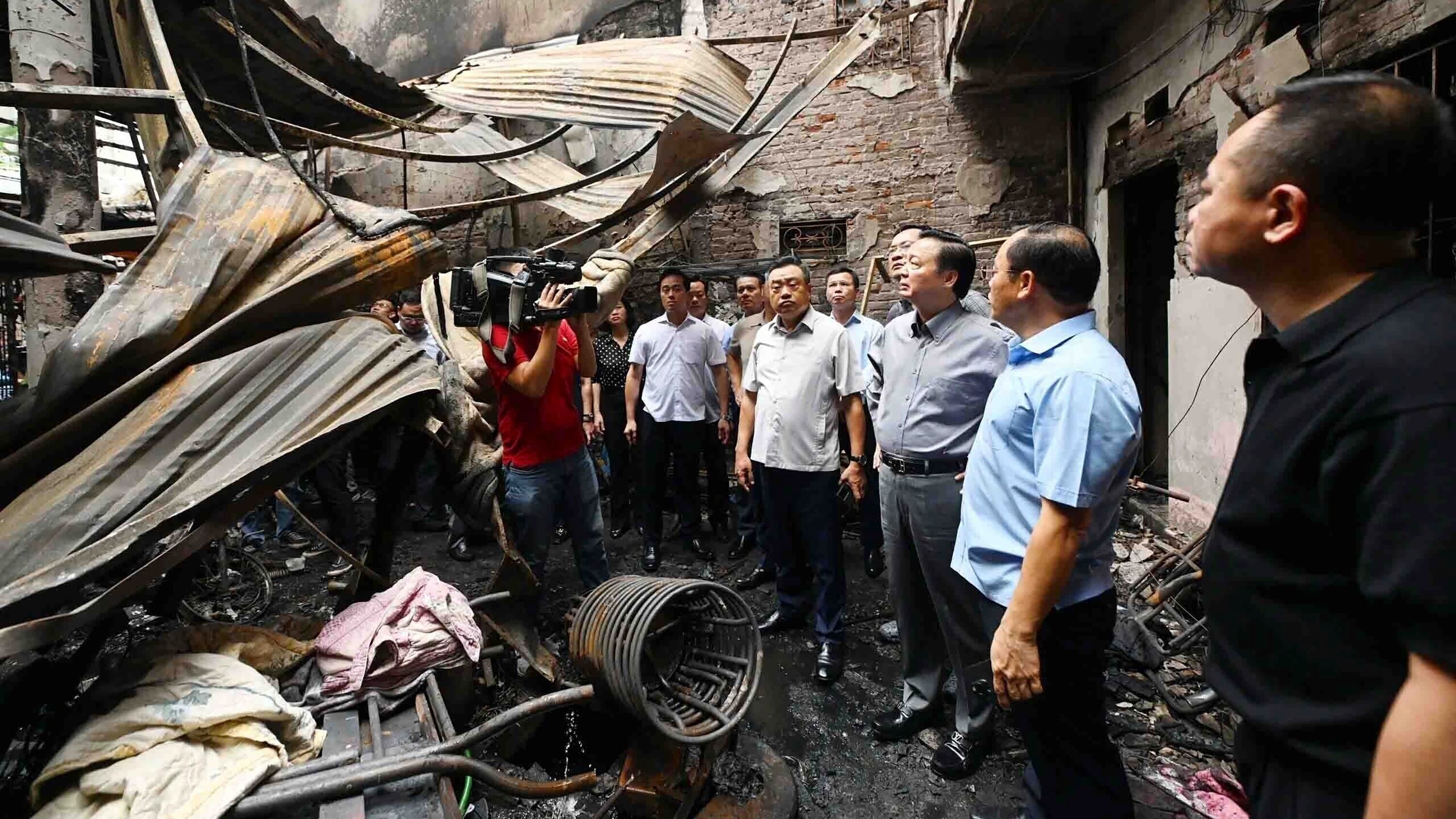 Officials visit the site of a house fire in Hanoi (Bui Van Lanh/VNA/AP)