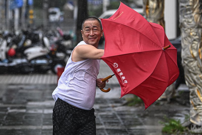 A man holding an umbrella struggles against the wind following the landfall of Typhoon Yagi in Haikou, south China’s Hainan Province (Pu Xiaoxu/Xinhua via AP)