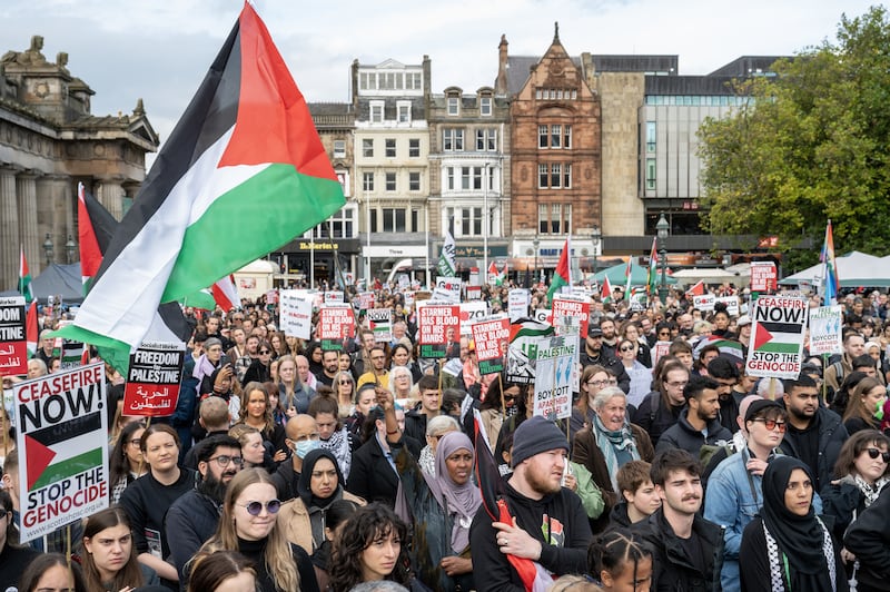 People take part during a silent funeral procession through Edinburgh city centre on Saturday