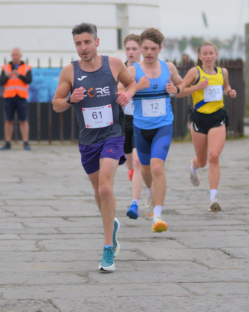 Group of runners in 5k race in front of white lighthouse