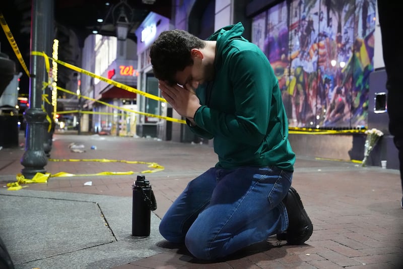 Matthias Hauswirth of New Orleans prays on the street near the scene (George Walker/AP)