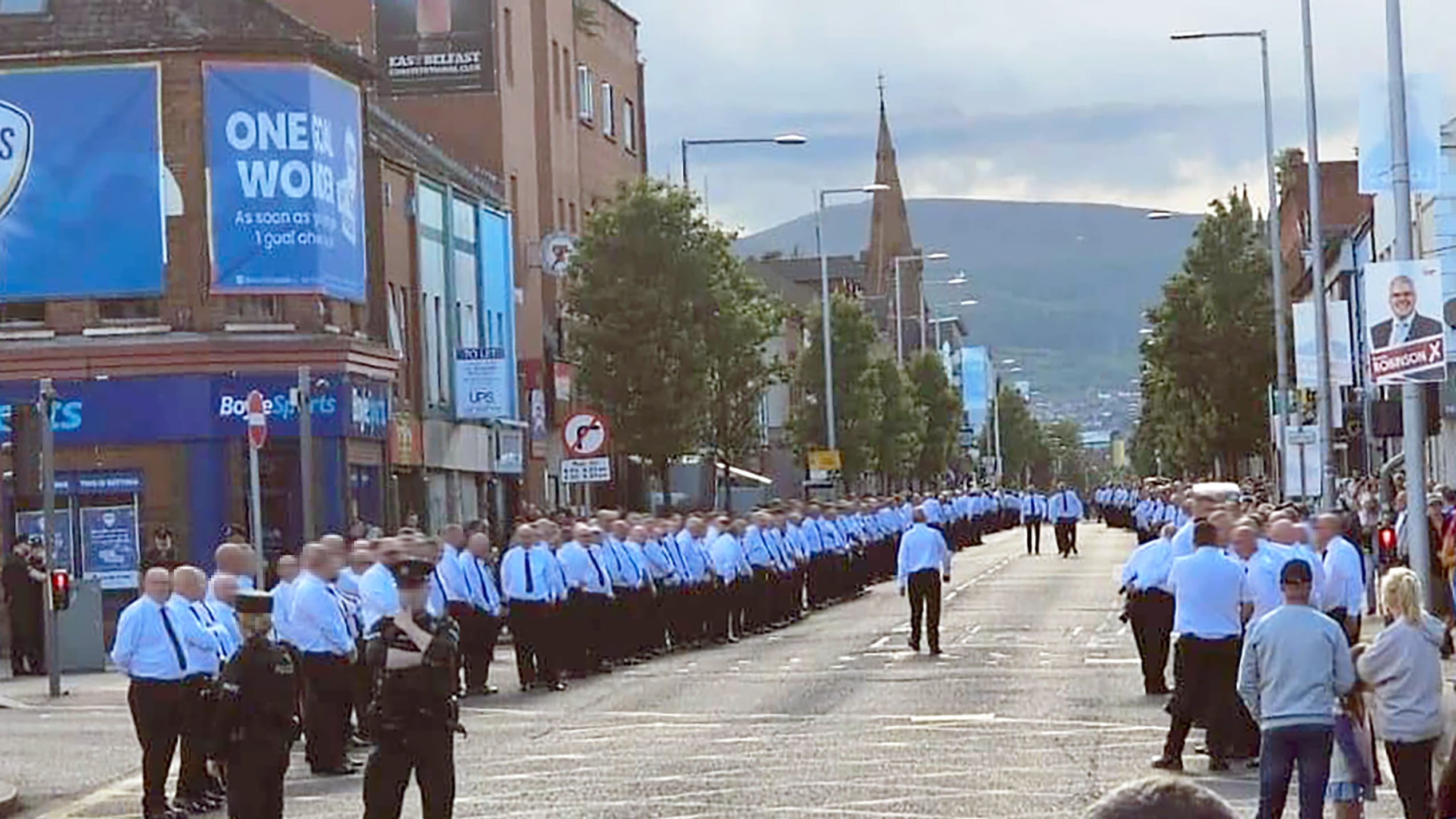 Hundreds of men in white shirts and black ties lined the route of a memorial parade for murdered UVF man Robert Seymour on the Newtownards Road
