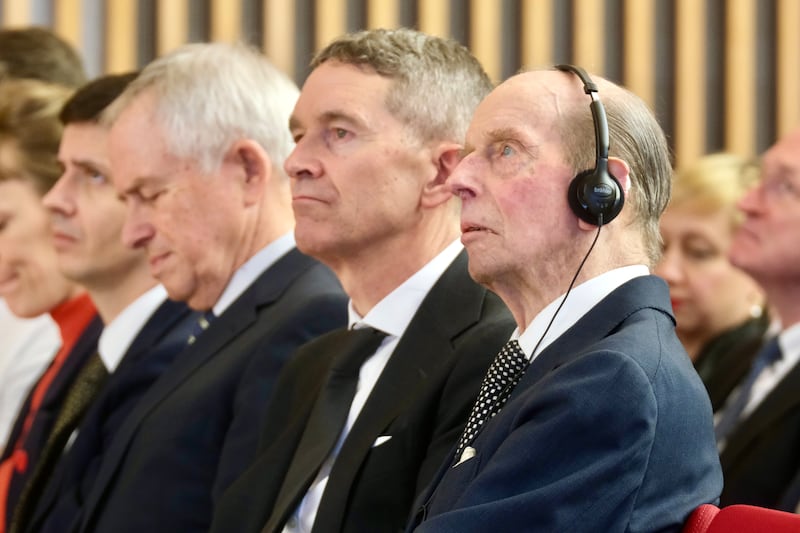 The duke listening to a translation on a set of headphones during the ceremony