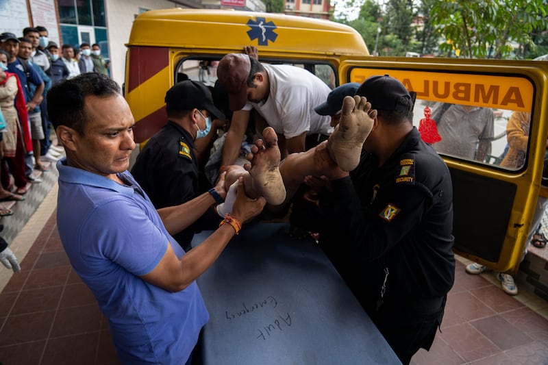 An injured man is taken to hospital for treatment (Niranjan Shrestha/AP)