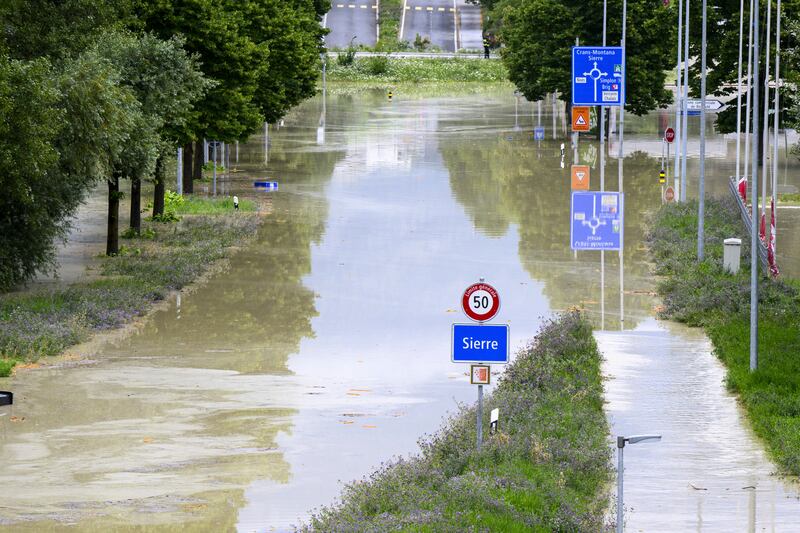 The Rhone river floods streets in Sierre, Switzerland, following heavy rain (Jean-Christophe Bott/Keystone/AP)