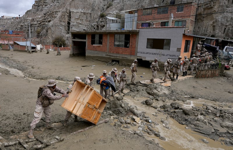 Soldiers recover a piece of furniture from a home flooded by a landslide caused by heavy rains in La Paz, Bolivia (Juan Karita/AP)