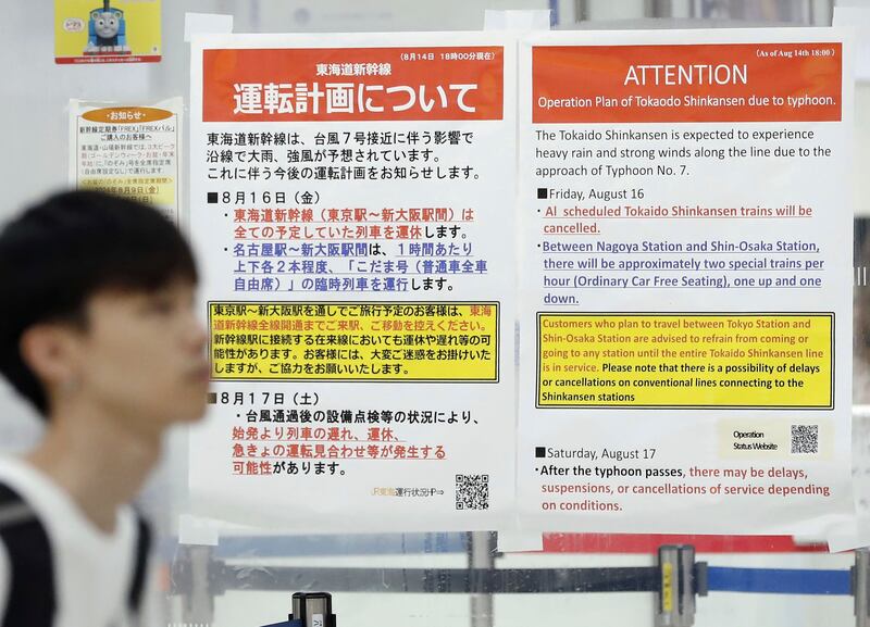 Station posters show the cancellation of Shinkansen bullet train services due to an approaching typhoon, at JR Tokyo station (Kyodo News via AP)