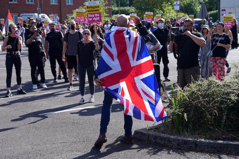 Protesters take part in a anti-racism 'Unity Rally' as a man wearing a Union Jack gestures towards them on August 9, 2024 in Crawley, England.  (Photo by Carl Court/Getty Images)