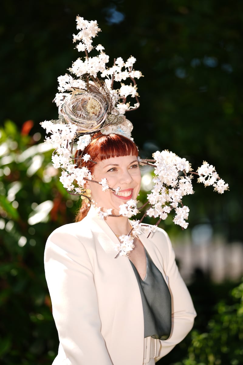A racegoer sports a naturally foraged fascinator exhibiting a nest and blossoms