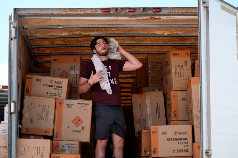 A worker uses a towel to wipe off sweat as he takes a break from unloading a trailer in Weldon Spring, Missouri (AP Photo/Jeff Roberson)