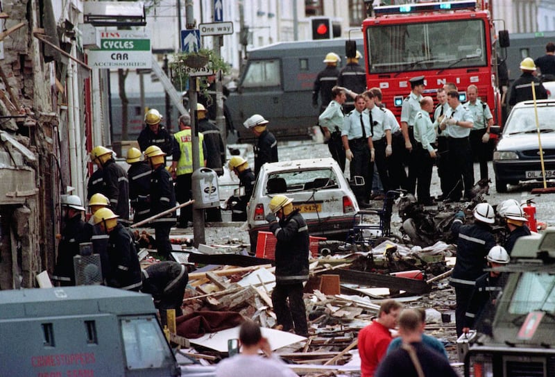 Police officers and firefighters inspecting the damage caused by a bomb explosion in Market Street, Omagh