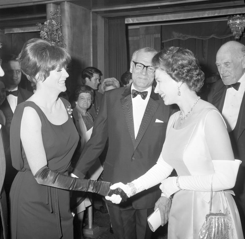 Queen Elizabeth II being presented to Dame Maggie Smith by Lord Laurence Olivier