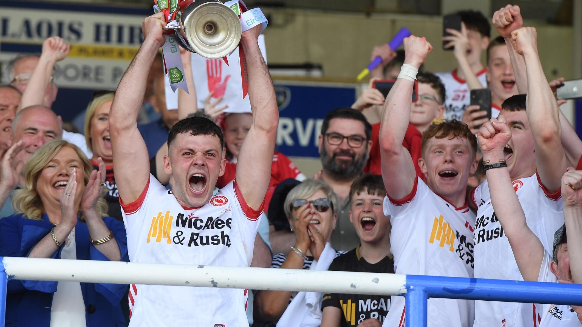 Michael Rafferty lifts the All-Ireland under-20 title with his Tyrone teammates on Sunday. Pictured over his left shoulder is Niall McKenna, chairman of the ‘Enough is Enough’ campaign group, set up in the aftermath of John Rafferty’s death in October 2022.