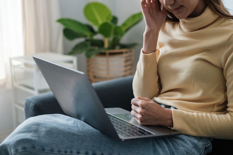 2J0WR5D Frustrated stressed woman sitting on sofa at home.