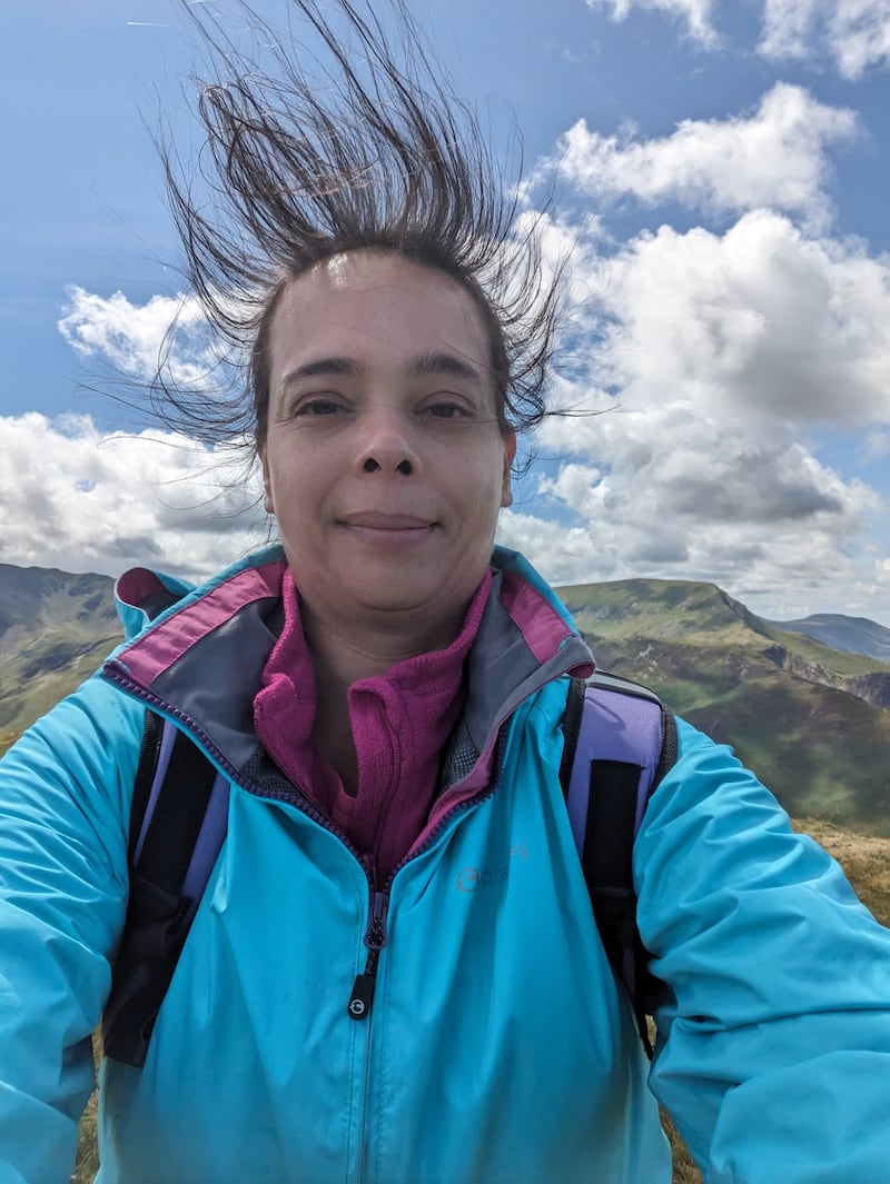 Dr Sarita Robinson pictured on a mountain with her hair standing on end