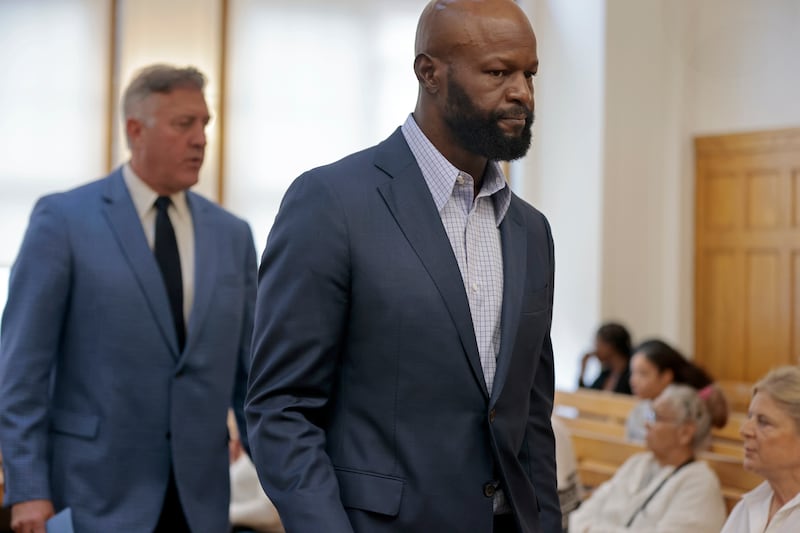 Former NFL football player Gosder Cherilus, right, leaves the courtroom in front of defence attorney Brian Sullivan, left, following his arraignment (Pat Greenhouse/AP)