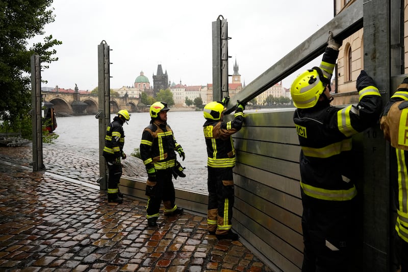 Firefighters adjust parts of the anti-flood barriers in Prague (Petr David Josek/AP)