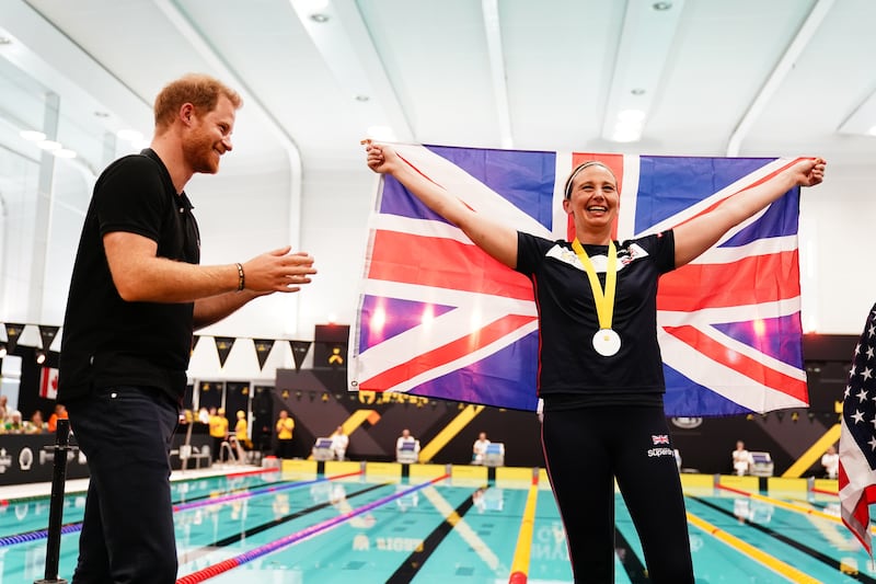 Harry congratulates a Team UK medal winner during the swimming at the Invictus Games at the Hague in 2022